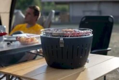 LotusGrill XL Hybrid Houtskoolbarbecue - Rood -Camping Promotiewinkel lotusgrill in gebruik met toppy shirtje 2