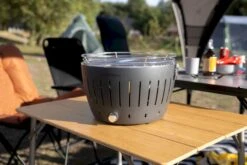 LotusGrill XL Hybrid Houtskoolbarbecue - Rood -Camping Promotiewinkel lotusgrill in zon op tafel 3